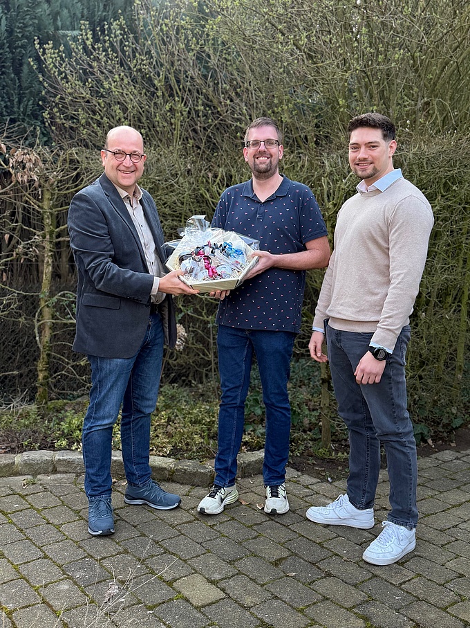 Kevin Bremerkamp (Mitte)  erhielt von Werkstattleiter Martin Heimbrock (links) und Teamkoordinator Dennis Glüsenkamp (rechts) ein kleines Präsent.