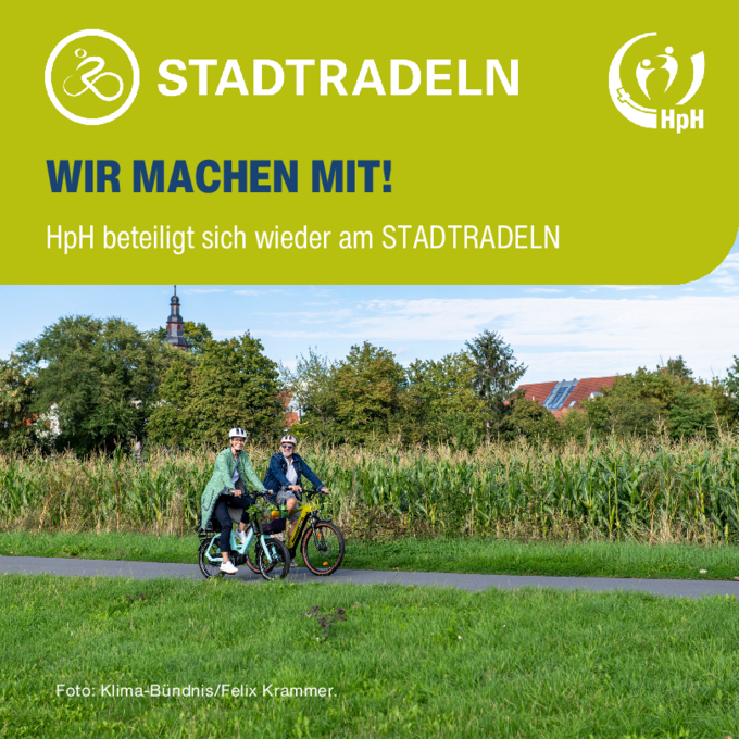Zwei Radfahrer fahren gemeinsam an einem Feld vorbei.