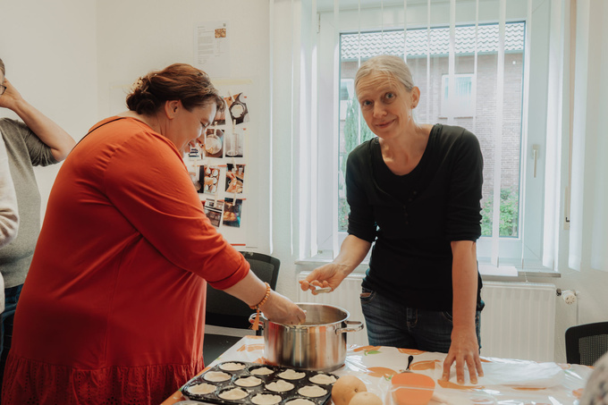 zwei Frauen stehen an einem Tisch und backen.