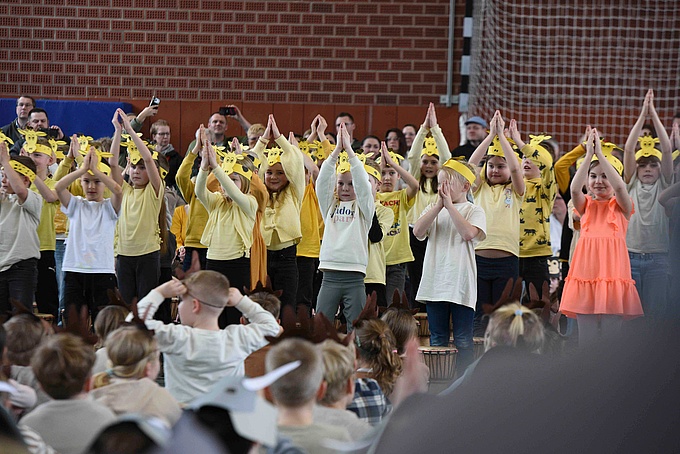 Mit ihren Armen formen die Zweitklässler*innen lange Giraffenhälse und tanzen zur Musik. 