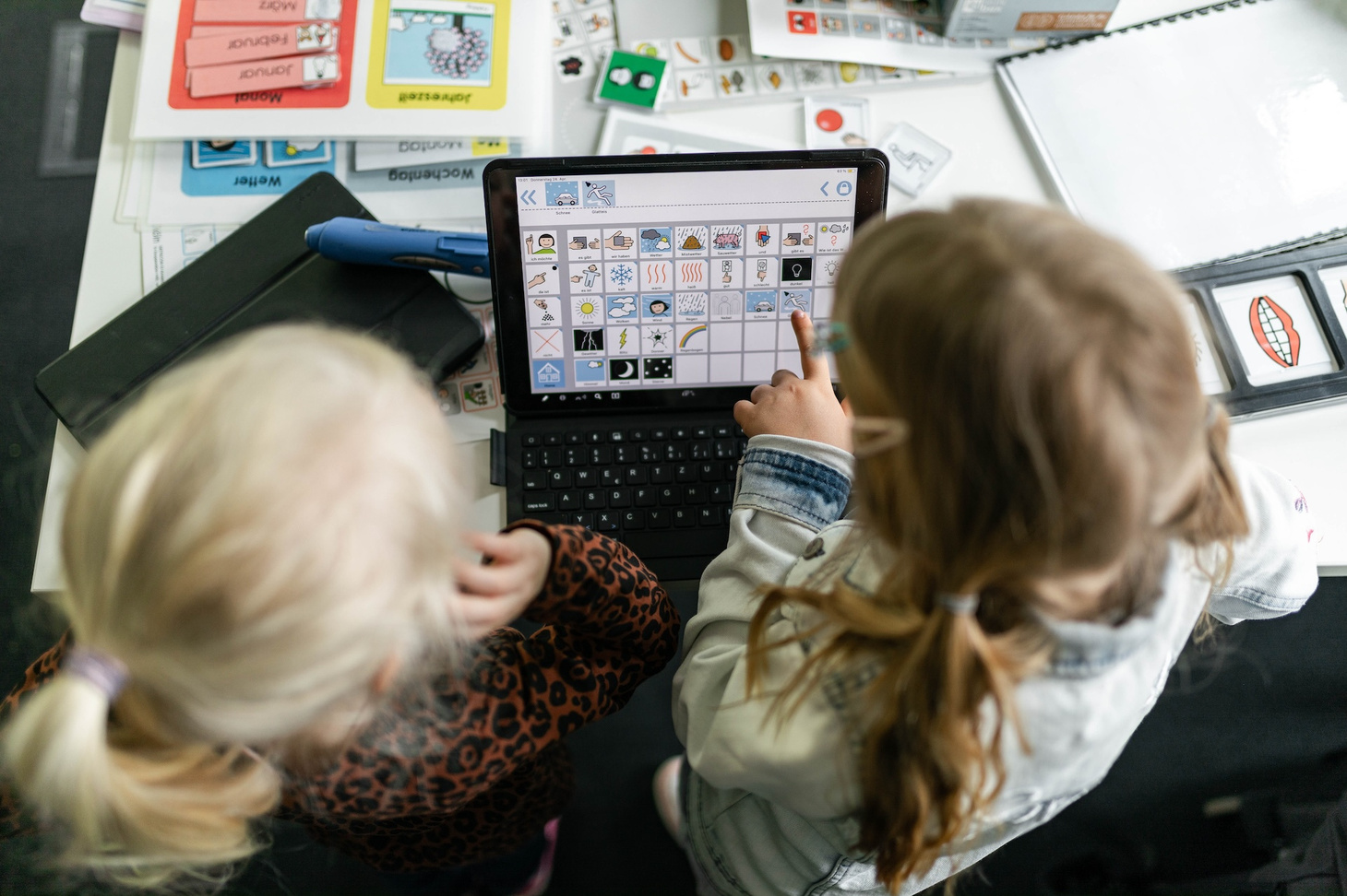 Zwei Kinder probieren einen Talker aus.