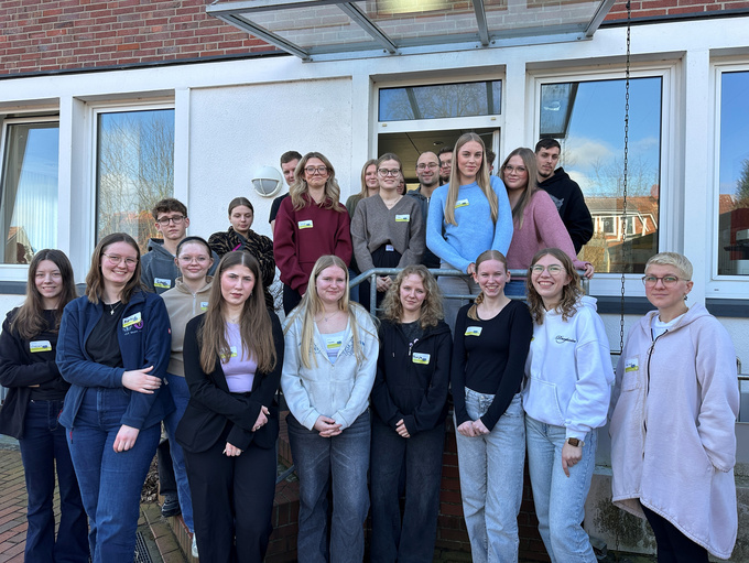 Eine Gruppe Menschen steht vor dem Eingang auf der Treppe Haus Mittendrin Bersenbrück.