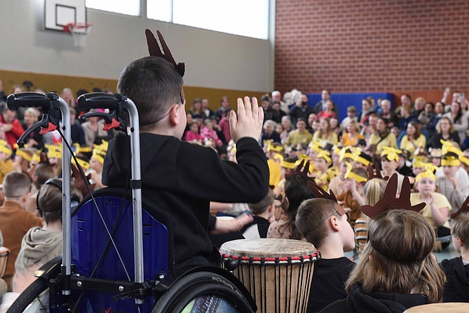 Ein Junge im Rollstuhl trommelt.