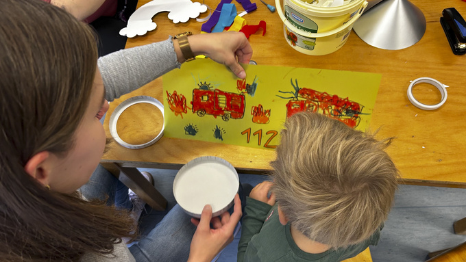 Eine Frau und ein Junge basteln eine Feuerwehr-Laterne.