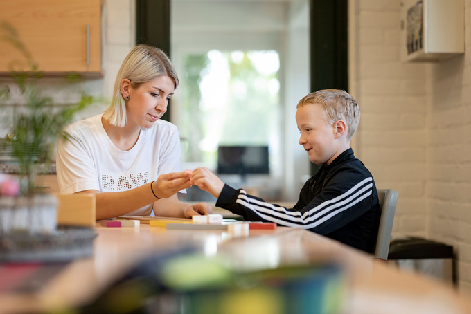 Frau sitzt mit Junge am Tisch