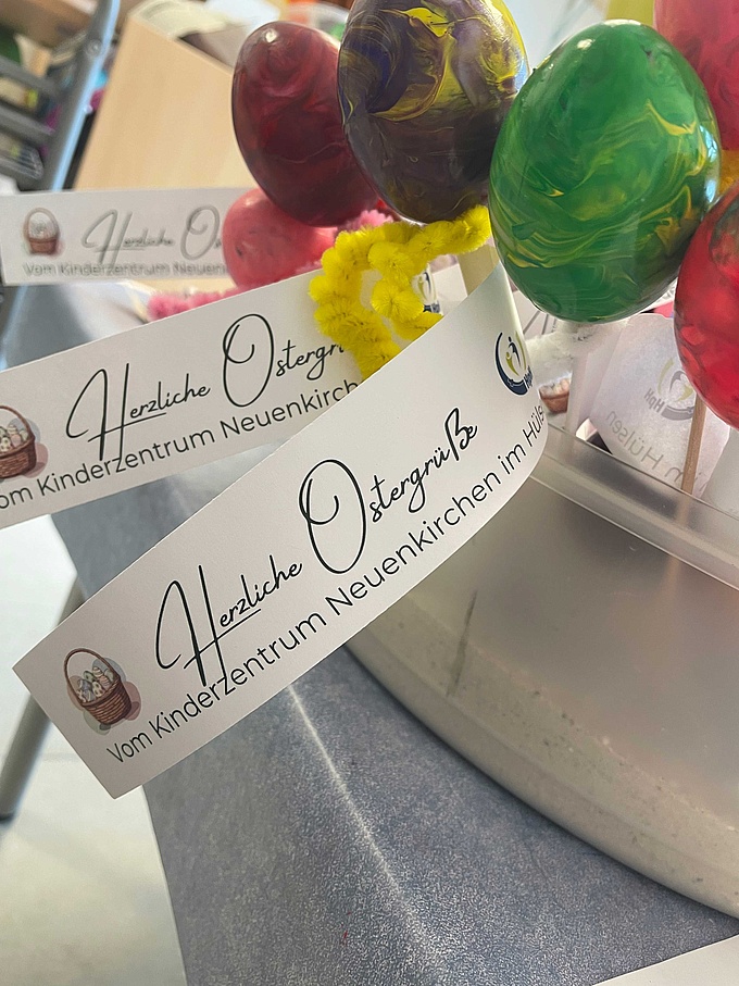 Geschenk an die Eltern: Selbstgemalte Ostereier mit einem Fähnchen und der Aufschrift "Herzliche Ostergrüße aus dem Kinderzentrum im Hülsen".