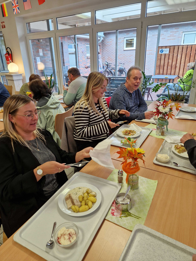 Die Tauschpartner sitzen beim Mittagessen bei Impuls Bramsche. 