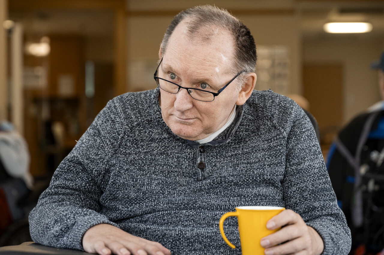 Eine Person sitzt an einem Tisch und spielt Mensch ärgere dich nicht.