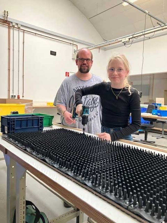 Eine Schülerin und ein Beschäftigter bei der Montage.