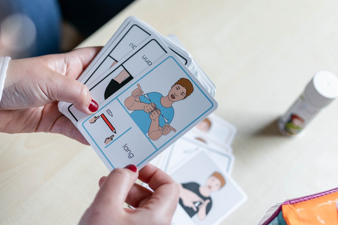 Karten mit Gebärden- eine Person hält eine Karte, eine andere macht die Gebärde.