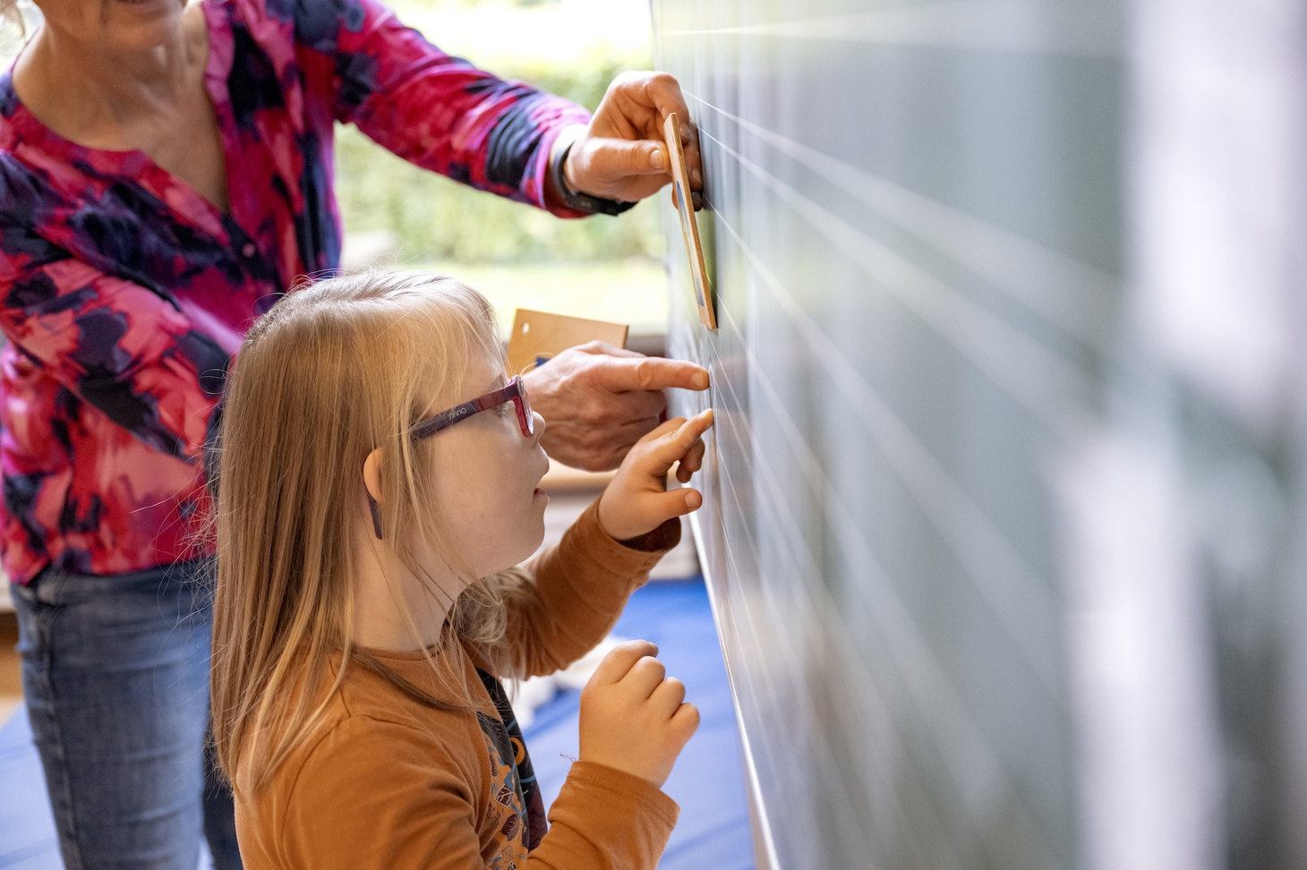Kind und PM schreiben an der Tafel.