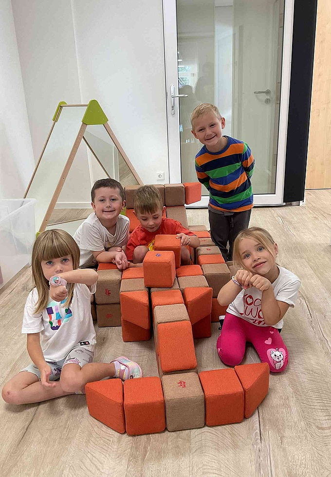 Mehrere Kinder spielen mit magnetischen Bausteinen.