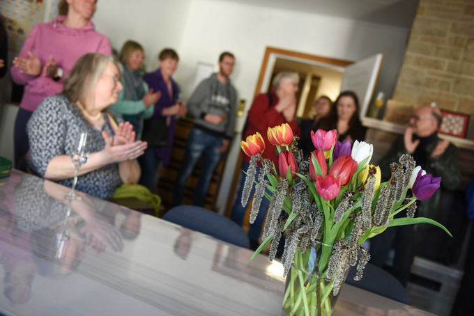 Mehrere Gäste klatschen bei der offiziellen Eröffnungsfeier. Auf einem Tisch stehen bunte Tulpen.