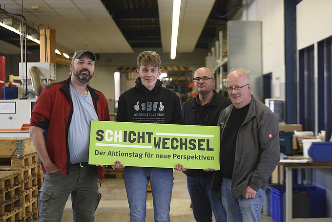 Marco Bruns, Laurin Finkemeier, Mark Strubbe und Rainer Ortbrink posieren für ein Foto im Metallbereich der WfbM in Bersenbrück. 