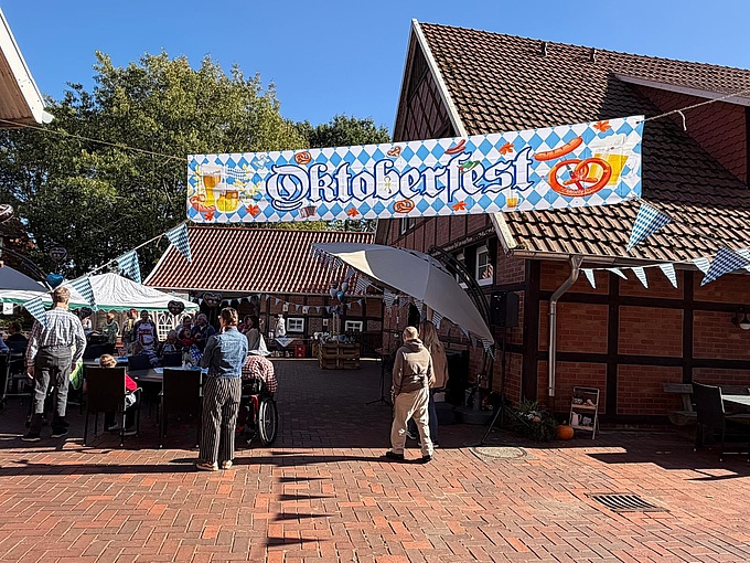 Ein Banner mit der Aufschrift "Oktoberfest" hängt am Eingang zum Innenhof. 