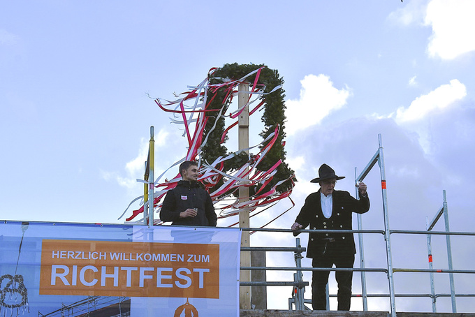 Zimmerermeister Franz-Josef Berensmeier steht auf dem Dach und spricht den Richtspruch.
